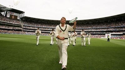 Shane Warne acknowledges the crowd as he walks off after taking his 700th Test wicket. (Action Images)