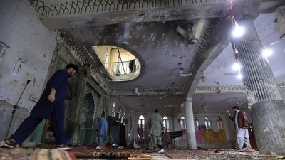 People walk amid the damages at the prayer hall after a bomb blast inside a mosque during Friday prayers in Peshawar, Pakistan, March 4, 2022. (Reuters)