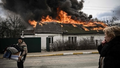 A man removes personal belongings from a burning house after being shelled in the city of Irpin, outside Kyiv. (AFP) A man removes personal belongings from a burning house after being shelled in the city of Irpin, outside Kyiv. (AFP)