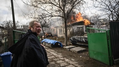 Yevghen Zbormyrsky, 49, stands in front of his burning home after it was hit by a shelled in the city of Irpin, outside Kyiv, on March 4, 2022. (AFP)
