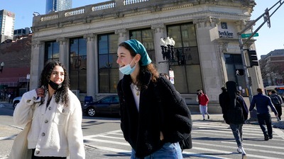 Passers-by wear masks as they chat with one another while crossing a street, in Boston. (AP)
