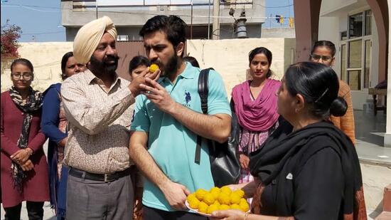 Parents of Harjinder Singh, 24, a medical student evacuated from Ukraine, offering him sweets after he returned to his home in Abohar, Punjab, on Friday. (HT Photo)