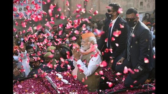 ?Prime Minister Narendra Modi greets supporters during a roadshow for the seventh and last phase of UP Assembly elections, in Varanasi, Friday, (PTI Photo)