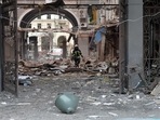 A firefighter walks among damages in a building entrance after the shelling by Russian forces.