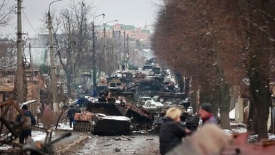 People look at the gutted remains of Russian military vehicles on a road in the town of Bucha, close to the capital Kyiv, Ukraine. (AP)