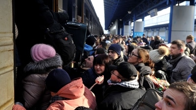 TOPSHOT - People try to get an evacuation train at Kyiv central train station. (Photo by Sergei CHUZAVKOV / AFP) (AFP) TOPSHOT - People try to get an evacuation train at Kyiv central train station. (Photo by Sergei CHUZAVKOV / AFP) (AFP)