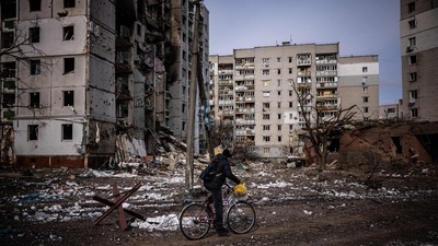 A man rides his bicycle in front of residential buildings damaged in yesterday's shelling in the city of Chernihiv. (AFP) A man rides his bicycle in front of residential buildings damaged in yesterday's shelling in the city of Chernihiv. (AFP)