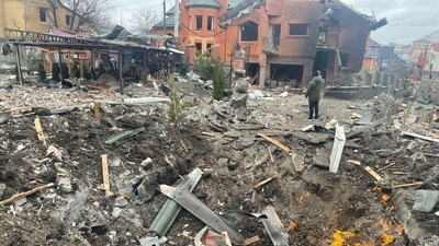Debris are scattered around the hole in a road at the site where several houses have been damaged by an explosion, following an air strike in Bila Tserkva, Kyiv. (Reuters)