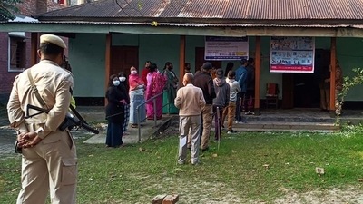 Police personnel stand guard while voters wait in a queue to cast their votes for the first phase of Manipur Assembly elections, at a polling booth, in Kangpokpi. (ANI) Police personnel stand guard while voters wait in a queue to cast their votes for the first phase of Manipur Assembly elections, at a polling booth, in Kangpokpi. (ANI)