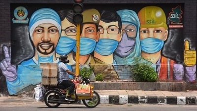 A motorist passes by a mural of frontline workers against coronavirus at RK Puram in New Delhi. (HT Photo) A motorist passes by a mural of frontline workers against coronavirus at RK Puram in New Delhi. (HT Photo)