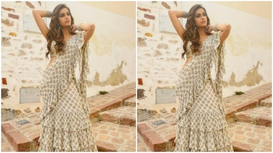 Keerthy decked up in a monochrome ruffle saree. The white saree came intricately decorated in black floral patterns. Keerthy paired it with a sleeveless ivory-white georgette blouse detailed in small mirror work.(Instagram/@keerthysureshofficial)