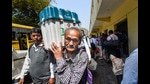 A polling officer carries an Electronic Voting Machine (EVM) and other election material, a day before the seventh and last phase of the Uttar Pradesh Assembly elections, March 6, 2022 (PTI)