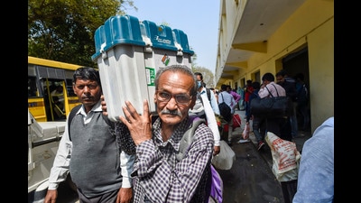 A polling officer carries an Electronic Voting Machine (EVM) and other election material, a day before the seventh and last phase of the Uttar Pradesh Assembly elections, March 6, 2022 (PTI)