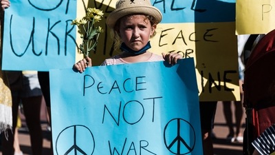 A young protestor holds an anti-war poster during a march on the Golden Mile Beach in Durban, as a show of support for the Ukrainian people, protesting against Russia's invasion. (AFP)