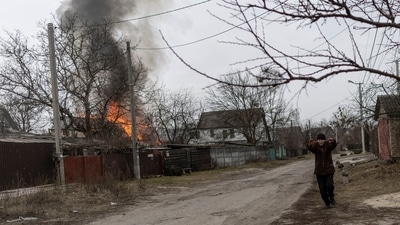 A local resident reacts as a house is on fire after heavy shelling on the only escape route used by locals to leave the town of Irpin, while Russian troops advance toward the capital, 24km from Kyiv, Ukraine. (REUTERS)