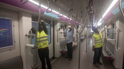 Men work inside a Metro coach at a car depot at Kothrud ahead of the inauguration of Pune Metro. (Pratham Gokhale/HT Photo)
