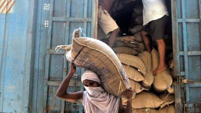 A labourer carries sacks containing rice grain to store at a Food Corporation of India (FCI) warehouse, Jammu, 2020 (Nitin Kanotra / Hindustan Times)