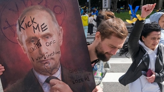 A demonstrator holds a sign showing a picture of Russian President Vladimir Putin during a rally in support of Ukraine in Los Angeles.(AFP)