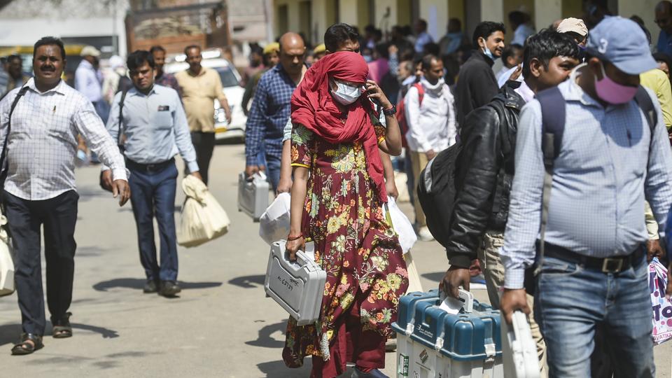 Polling officers carrying EVMs and other election material leave for their respective polling booths, at a distribution centre at Pahadiya Mandi, in Varanasi on Sunday. (PTI) Polling officers carrying EVMs and other election material leave for their respective polling booths, at a distribution centre at Pahadiya Mandi, in Varanasi on Sunday. (PTI)