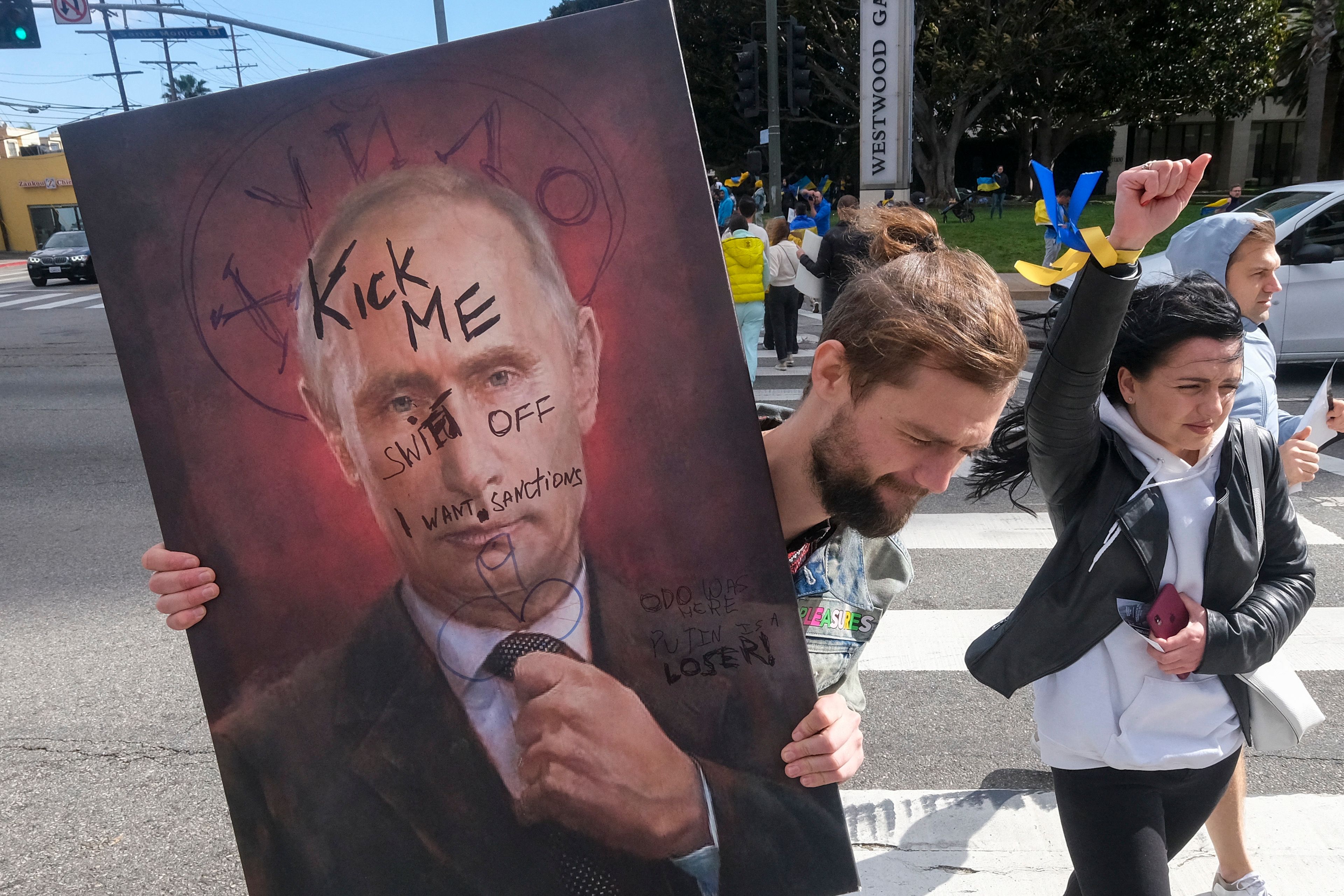 A demonstrator holds a sign showing a picture of Russian President Vladimir Putin during a rally in support of Ukraine in Los Angeles. (AFP) A demonstrator holds a sign showing a picture of Russian President Vladimir Putin during a rally in support of Ukraine in Los Angeles. (AFP)
