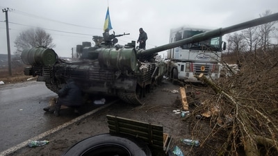 A Ukrainian serviceman stands at a captured Russian tank, amid the Russian invasion of Ukraine, in the north of the Kharkiv region. (REUTERS)