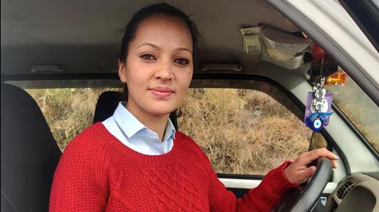 The mother of two, Meenakshi Negi has the distinction of being the first woman cabbie with tribal roots in Himachal Pradesh. She hails from a remote village in Kinnaur. (HT Photo)