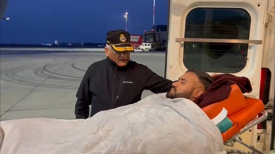 Union minister VK Singh comforts Delhi resident Harjot Singh, who was shot at four times in Ukraine, as he is being taken inside an IAF aircraft to be flown back to India from Poland. (Screengrab/VK Singh Twitter)