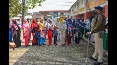 A police personnel stands guard as citizens wait to cast their vote, during the first phase of Uttar Pradesh assembly elections, in Muzaffarnagar. (PTI file photo)