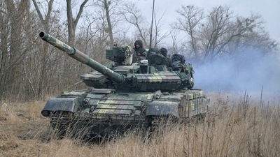 Service members of the Ukrainian armed forces are seen atop of a tank at their positions outside the settlement of Makariv, amid the Russian invasion of Ukraine, near Zhytomyr. (REUTERS)
