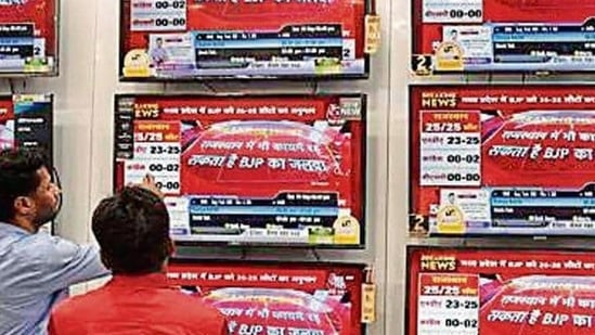 File photo of people watching exit poll predictions by various news channels in an electronics shop in New Delhi.(HT)
