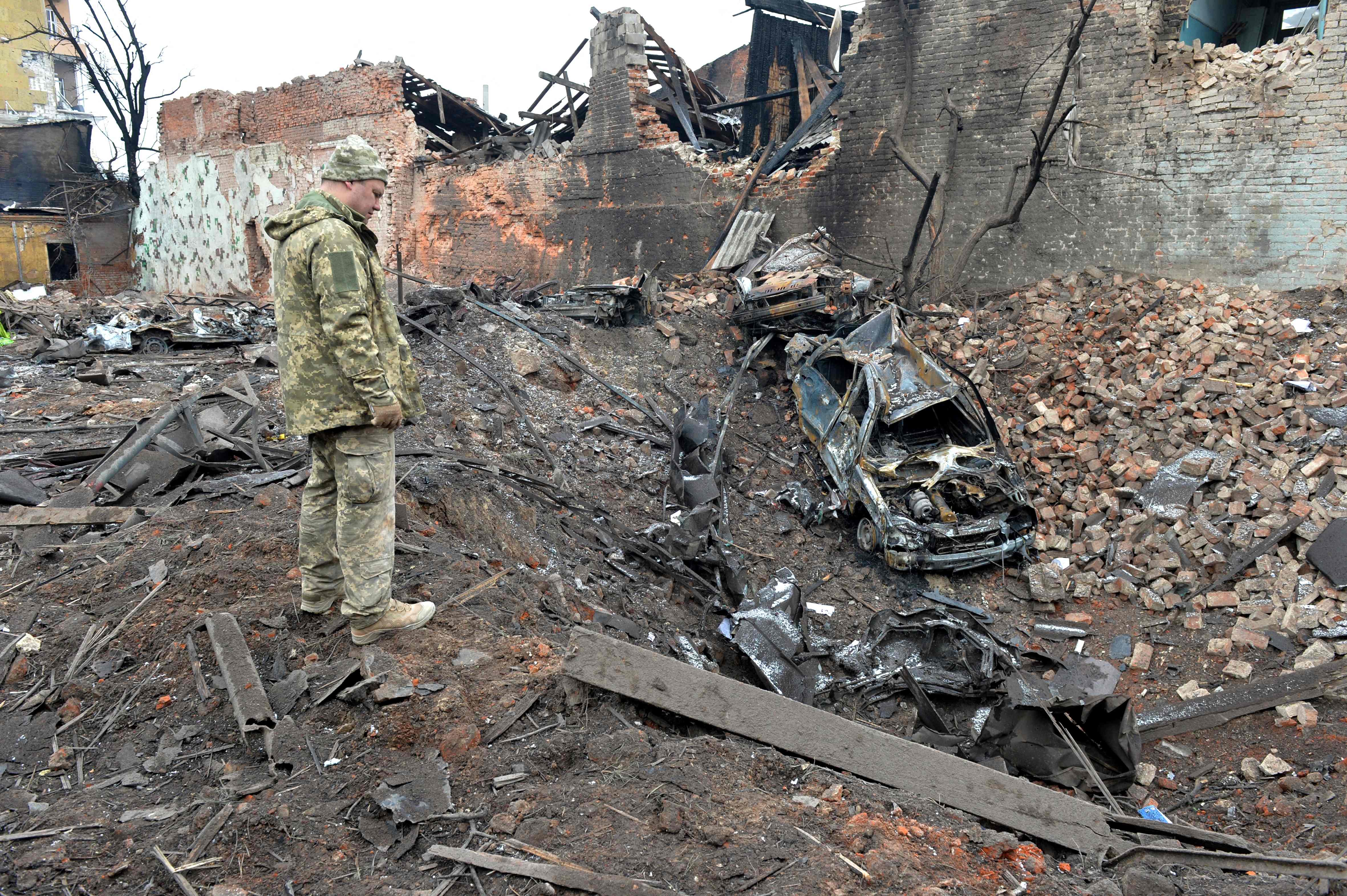 A Ukrainian serviceman looks at destructions following a shelling in Ukraine's second-biggest city of Kharkiv. (AFP)