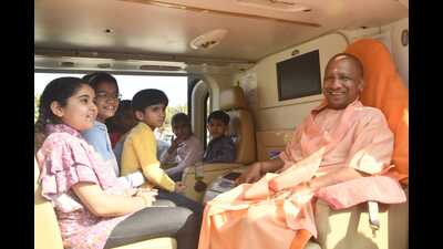 Yogi Adityanath sitting with children in the helicopter in Gorakhpur on Wednesday. (HT Photo)