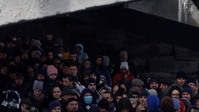 People wait below a destroyed bridge to cross a river as they flee from advancing Russian troops whose attack on Ukraine continues in the town of Irpin outside Kyiv, Ukraine.&nbsp; (REUTERS)