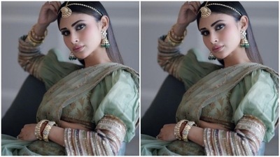 Mouni's saree came intricately detailed in golden floral patterns. She paired it with a pastel green blouse with dramatic sleeves lined in golden zari. (Instagram/@imouniroy)