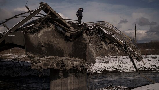 Kyiv: A man stands atop a destroyed bridge in Irpin, on the outskirts of Kyiv, Ukraine, Tuesday, March 8, 2022.AP/PTI(AP03_09_2022_000001B)(AP)
