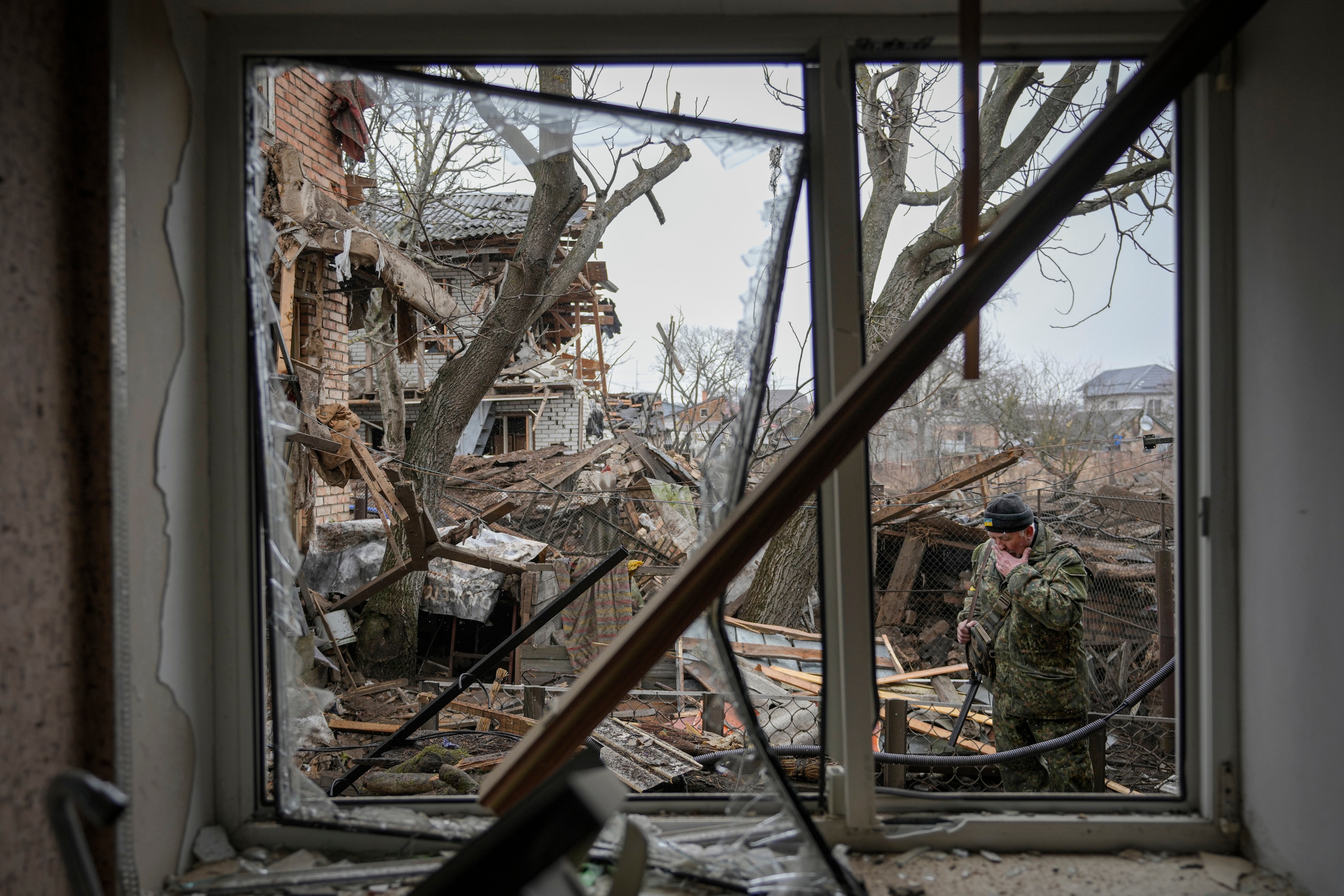 A member of territorial defense wipes his face in the backyard of a house that was damaged by a Russian airstrike, according to locals, outside Kyiv, Ukraine. (AP)