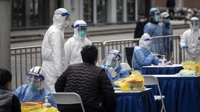 Health workers tests for Covid outside of a clothing market in Shanghai, China. (Bloomberg) Health workers tests for Covid outside of a clothing market in Shanghai, China. (Bloomberg)