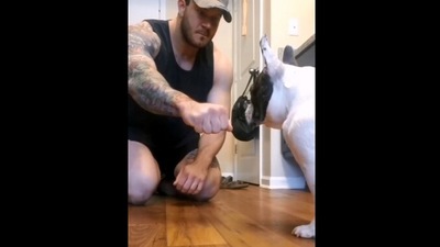 The image, taken from the video, shows the man sitting in front of the dog about to perform the magic trick. (Screngrab)