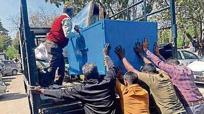Chandigarh MC taking away goods kept on the road and other non-designated places while removing encroachments at motor market. (HT Photo)