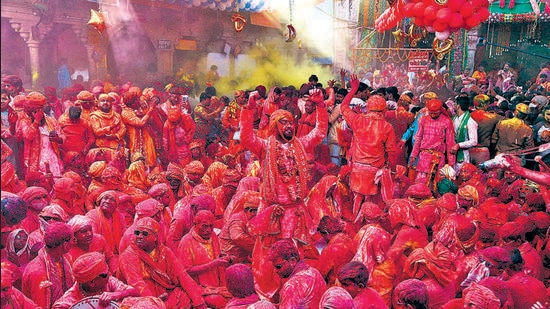 BJP supporters smeared in colours celebrate in Barsana village of Uttar Pradesh on Thursday. (AFP)