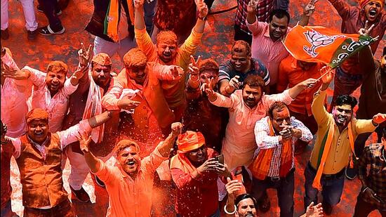 Supporters of Bharatiya Janata Party (BJP) celebrate outside the party office in Lucknow after the party appeared set to return to power in Uttar Padesh elections (AFP)