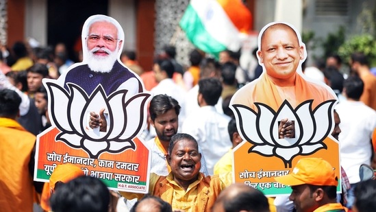 A Bharatiya Janata Party (BJP) supporter holds the cutouts of Prime Minister Narendra Modi and Uttar Pradesh Chief Minister Yogi Adityanath.(ANI)
