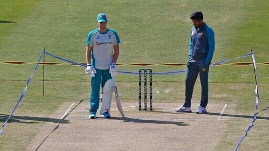 Pakistan's Babar Azam, right, and Australia's Steve Smith examine pitch following overnight rainfalls before start the 4th day play of first cricket test match between Pakistan and Australia at the Pindi Stadium, in Rawalpindi.(AP)