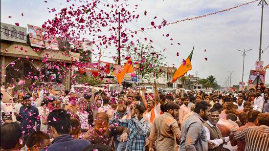 Bharatiya Janata Party supporters celebrate the party’s victory with flowers at Gallamandi Naubasta in Kanpur on Thursday. (PTI)