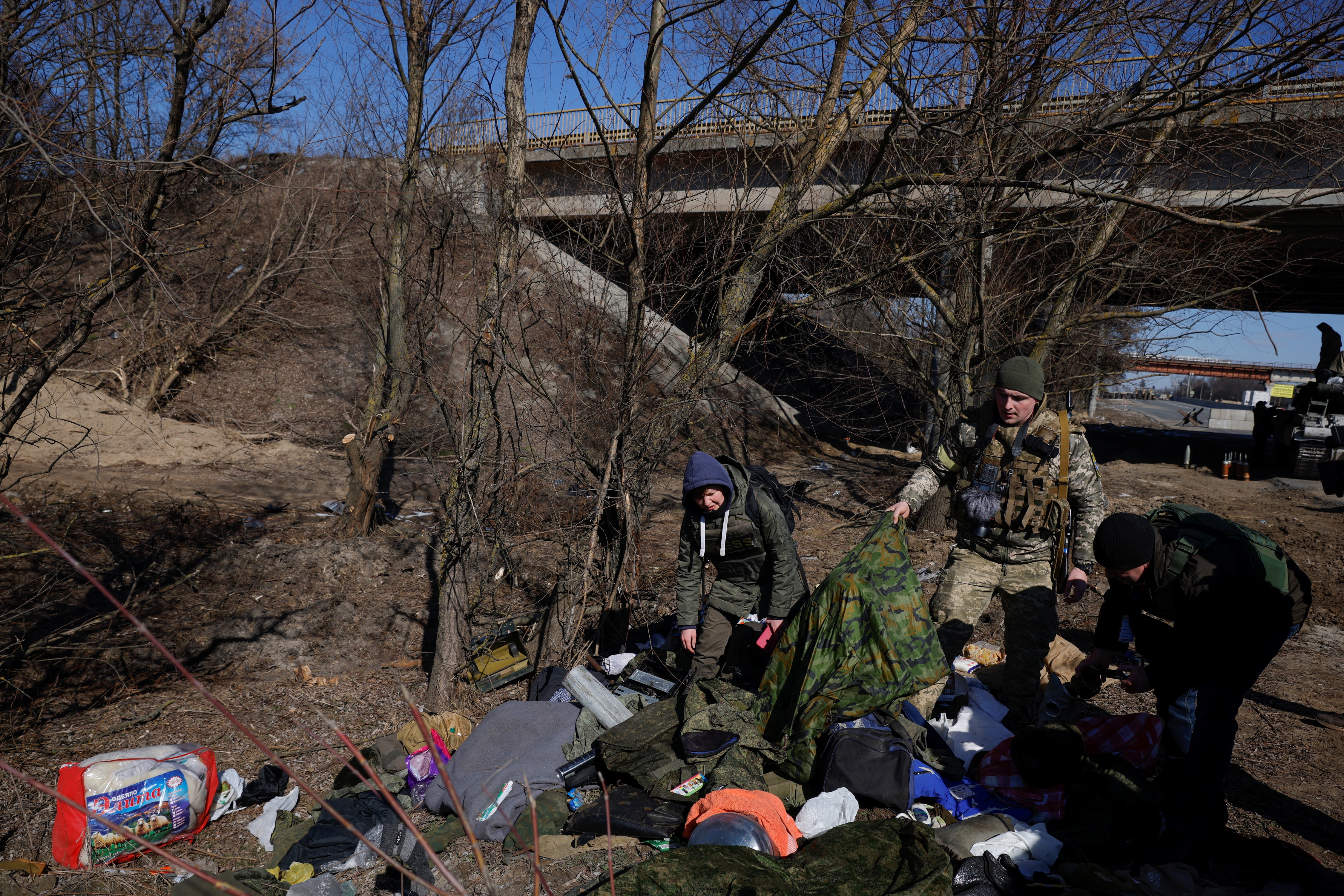 Members of the Ukrainian armed forces go through belongings Russian soldiers left behind after Ukrainian forces routed their armoured vehicles. (Reuters)