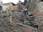 A Ukrainian serviceman looks at destructions following a shelling in Ukraine's second-biggest city of Kharkiv.