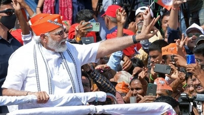 PM Modi waved to people as his roadshow began from the airport to Kamalam, BJP's state headquarters in Gandhinagar. (AFP) PM Modi waved to people as his roadshow began from the airport to Kamalam, BJP's state headquarters in Gandhinagar. (AFP)