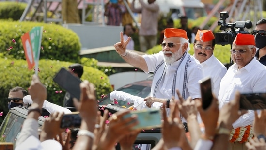 Ahmedabad: Prime Minister Narendra Modi flashes the victory sign during a roadshow after BJP's victory in the recent Assembly polls, in Ahmedabad, Friday, March 11, 2022. (PTI Photo)(PTI03_11_2022_000021B)(PTI)