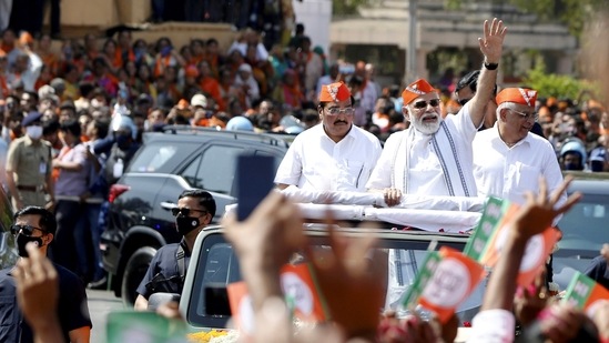 Prime Minister Narendra Modi waves at the supporters during a roadshow after BJP's victory in the recent Assembly polls, in Ahmedabad. (PTI)