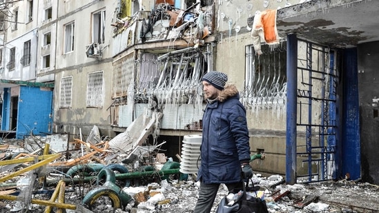 A man leaves an apartment building damaged after shelling the day before in Ukraine's second-biggest city of Kharkiv.&nbsp;